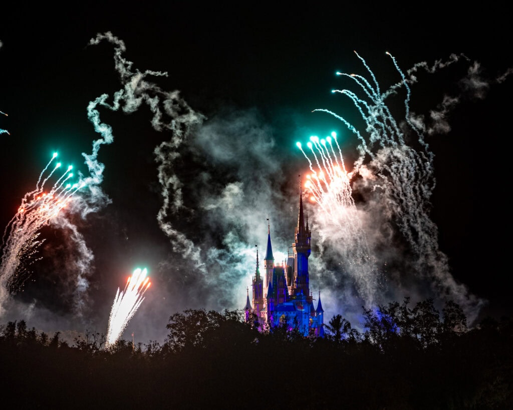 Magic Kingdom Christmas Party fireworks illuminating the night sky with vibrant colors, captured at 200mm using a Nikon 70-200mm lens from the Grand Floridian Resort.