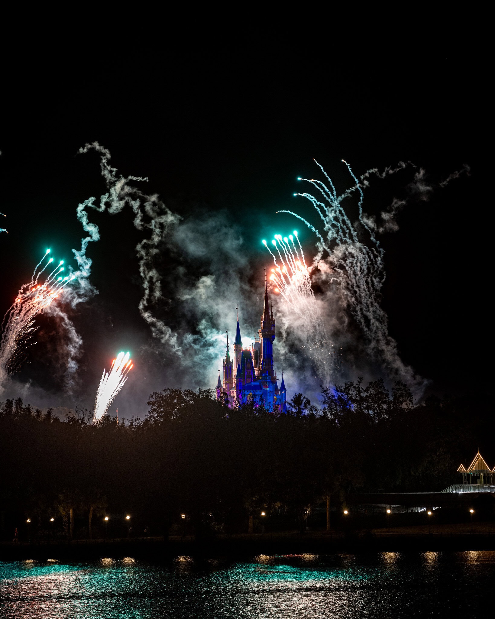 Magic Kingdom Christmas Party fireworks illuminating the night sky with vibrant colors, captured at 200mm using a Nikon 70-200mm lens from the Grand Floridian Resort.