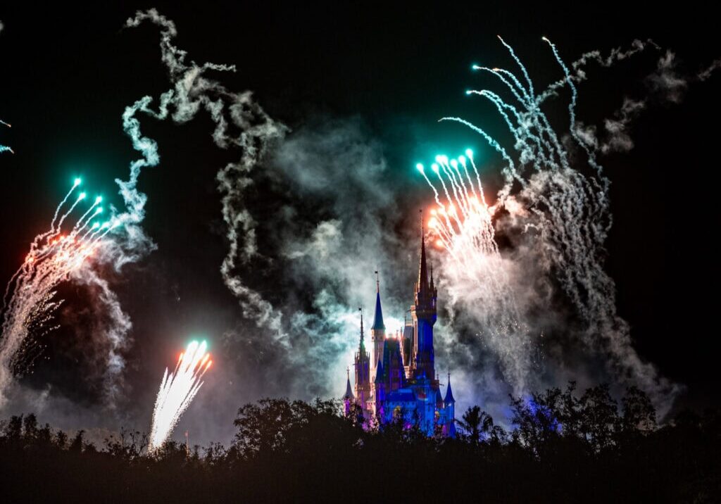 Magic Kingdom Christmas Party fireworks illuminating the night sky with vibrant colors, captured at 200mm using a Nikon 70-200mm lens from the Grand Floridian Resort.